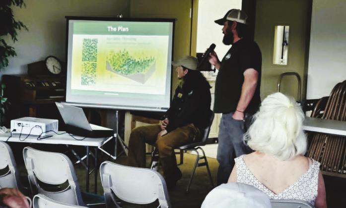 Danny Schell (standing and talking) and Thomas Hatling (seated) from the Fremont Office of the Colorado State Forest Service started the Community Meeting about Forest Health and Fire Mitigation. Photo by Shirley Pigg