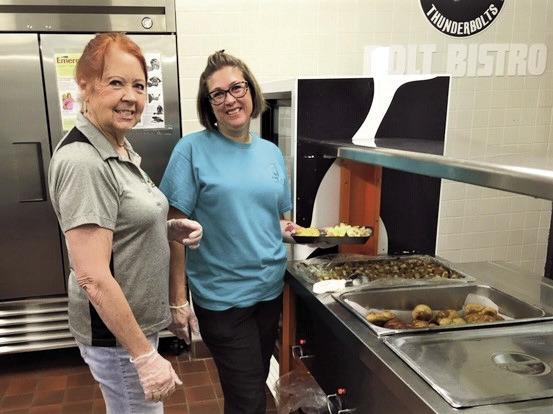 Michelle Dennis (R) and Susan Cronk serve 40-50 people daily at the Craver Middle School located summer food program. Courtesy Photo
