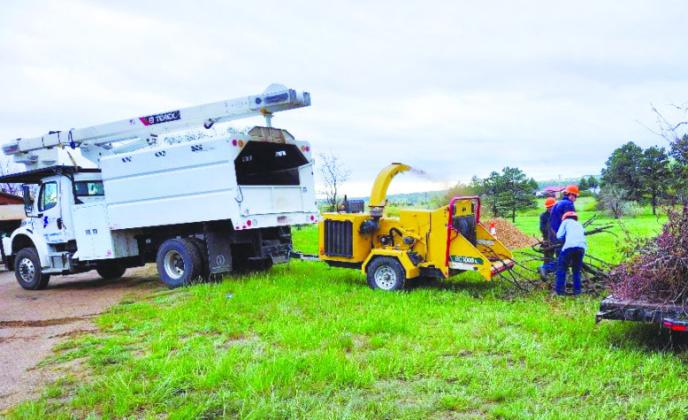 San Isabel Electric provided a truck and a massive chipper to get rid of tree branches for the Greenhorn Valley Community Clean-Up. Photo by Shirley Pigg