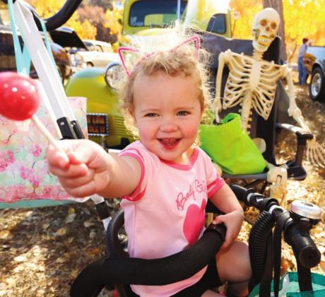 Classic car owners pass out candy to trunk-or-treater Lillian Colton on Saturday, Oct. 30, at Greenhorn Meadows Park in Colorado City. Photo by Emily Colton of San Isabel Photography