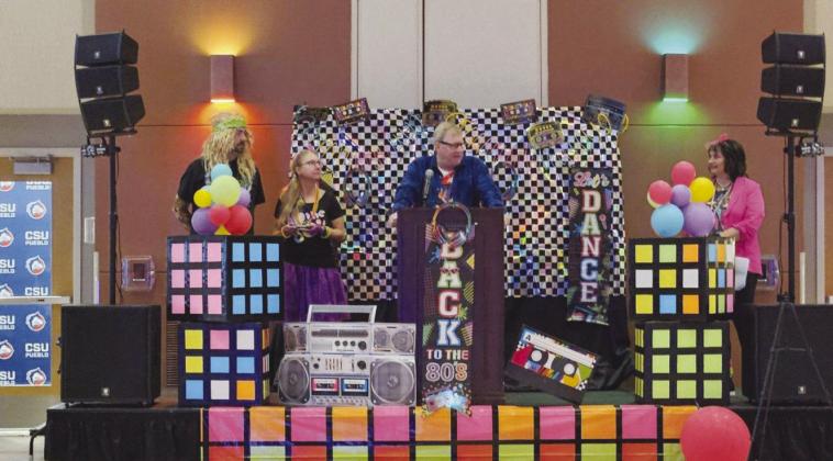 Carma Loontjer, Pueblo West Chamber of Commerce President (far right), presents the 2024 Business of the Year plaque to Sales Manager Troy English, Community Relations Manager Emily Briggs, and Highline Internet CEO Rob Mills (L to R) at a 1980’s themed ceremony. Courtesy Photo