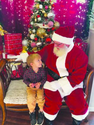 Jolly Santa listened closely as one youngster shared his wish list. Courtesy Photo