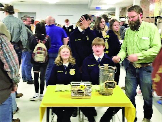 Rye High School Future Farmers of America Advisor Ethan Beeman (R) shares a moment with FFA members while taking tickets for the 7th Annual Rocky Mountain Oyster Fry and Auction. Photo by Shirley Pigg