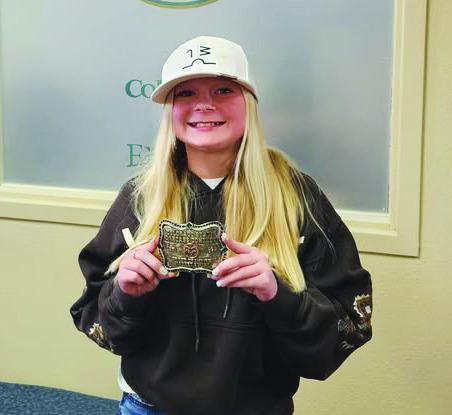 Stormy Kenney displays the belt buckle she won for the Statewide Colorado State Carcass Contest Grand Champion market swine winner for 2024. Courtesy Photo