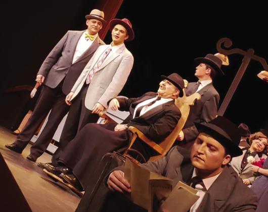 George Bailey in front played by Oliver Carlon and Henry Potter played by Jeffery Orman, as well as other town members in Bedford Falls Courtesy Photo