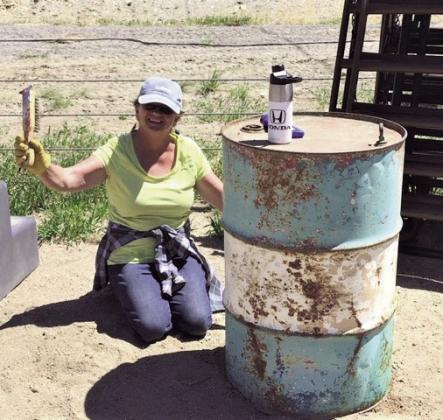Dede Downs scrapes rust off of a barrel while getting equipment ready at the RCC Saddle Club arena. Photo by Shirley Pigg
