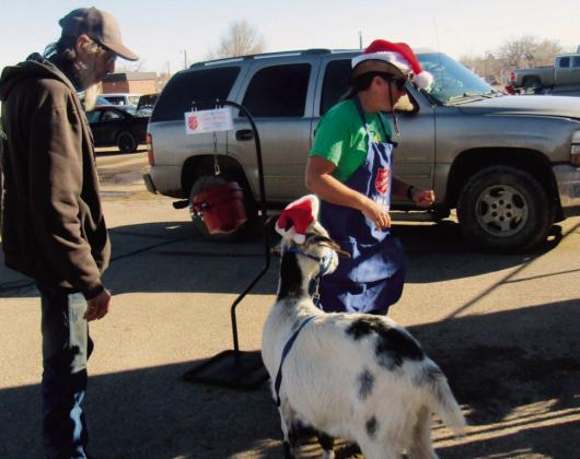 Nan Hassey set up a Salvation Army collection site, with a twist. She is accompanied by her beautiful goat and has taught the goat to ring the traditional Salvation Army volunteer bell. Photo by Shirley Pigg