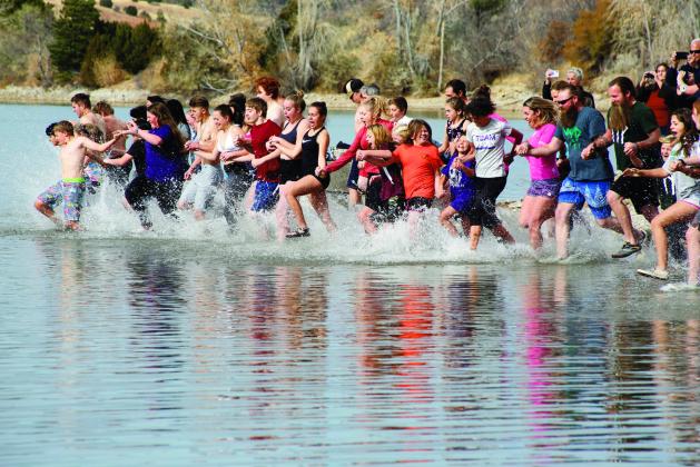 Participants in the 2021 Maggie Drew Peters Polar Plunge enter the water at Lake Beckwith in Colorado City to raise scholarship funds for Rye High School students.
