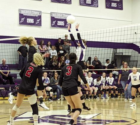 Bella Bond spikes the ball over the net in post-season play on the Thunderbolt’s home floor. Photo by Deb Straub