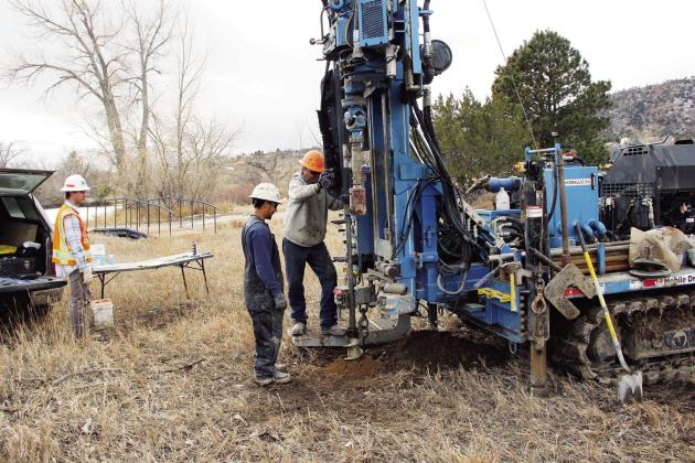 Lenny Jecminek (R), driller for RJU Consultants, prepares to take another sample of the soil near Lake Beckwith.