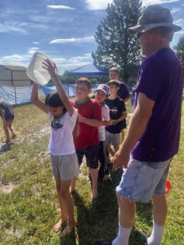 It's not easy passing a bucket of water over your head but these VBS participants are giving it their best. Courtesy Photo