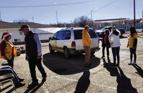 The Lions Club serves the community as members load a car during the holiday food distribution. Photo by Shirley Pigg
