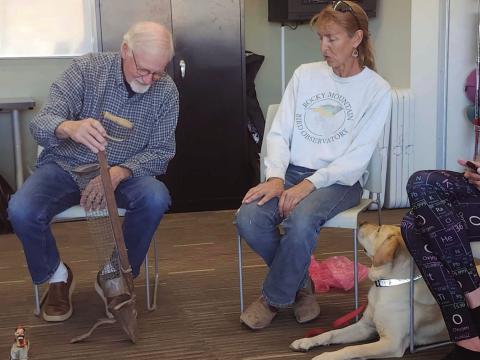 Neil Elliot examines an old potato planter that Patty Knupp brought to Adult Show and Tell. Photo by Shirley Pigg
