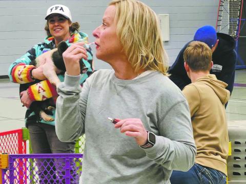 Best Photo - First Quarter 2025 - Shirley Pigg caught this photo as Craver Middle School teacher Erin Sonnleiter prepares to Kiss a Pig to benefit the Craver FFA Chapter Photo Archives