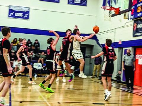 Rye High School Thunderbolt Brandon Benz (#24) makes an evasive move and basket against a Peyton player. Photo by Deb Straub