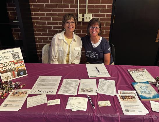 Brynda Aker (L) and Sally Harrison share information about Moms in Prayer from an Open House they attended.. Courtesy Photo