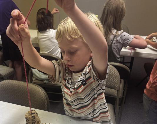 A young man shares the bird feeder he made in the creation science class at the Greenhorn Valley Baptist Church Courtesy Photo
