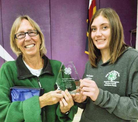 Photo by Kathy Wolyn Christina Olhsen receives her Leader Hall of Fame Award from Kaitlyn Frick, president of the Greenhorn Kickers 4-H Club.