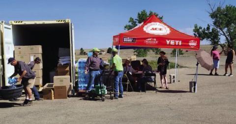 Rye Church of Christ volunteers will be stocking and handing out supplies just as they did while they were at the Greenhorn Valley Ace Hardware parking lot. Bill Mansfield (l) unloads water, an unknown person sorts through boxes, and Darrel Proctor and Jim Ragan discuss the operation while other volunteers assist customers at the tables under the tent. Photo by Shirley Pigg