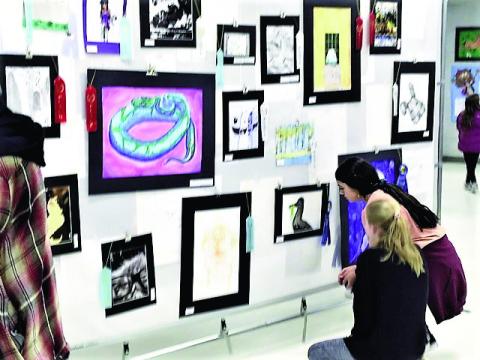 Visitors at the 2023 Student Art Show and Concert examine some of the art displayed at Rye High School for the March 8 event. Photo by Shirley Pigg