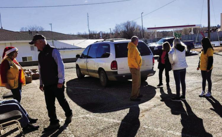 The Lions Club serves the community as members load a car during the holiday food distribution. Photo by Shirley Pigg