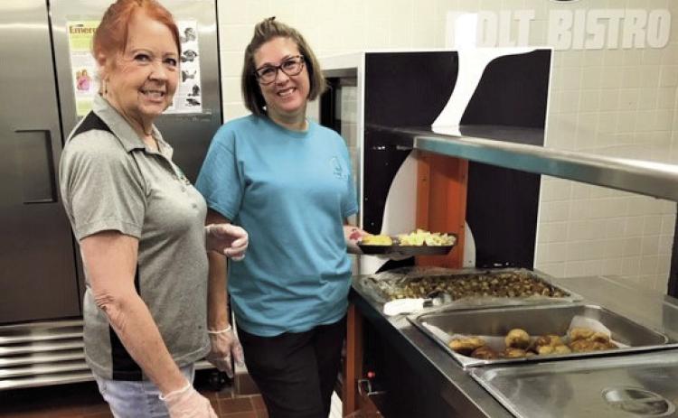 Michelle Dennis (R) and Susan Cronk serve 40-50 people daily at the Craver Middle School located summer food program. Courtesy Photo