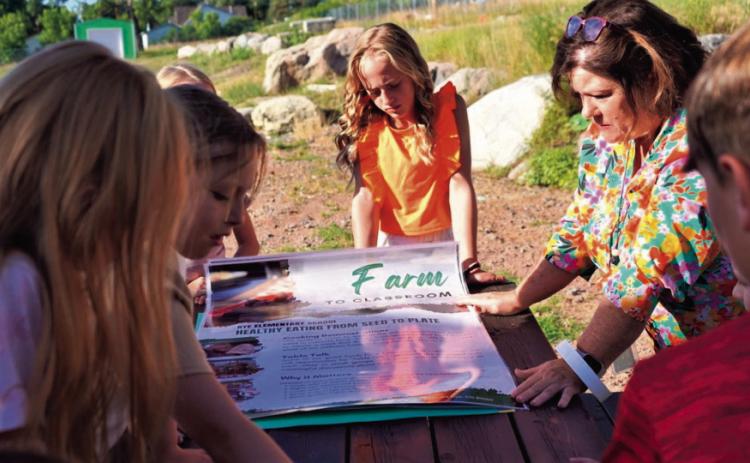 Rye Elementary Principal Lisa Asbury and students examine Farm to Table material as they discuss plans for the greenhouse program. Courtesy Photo