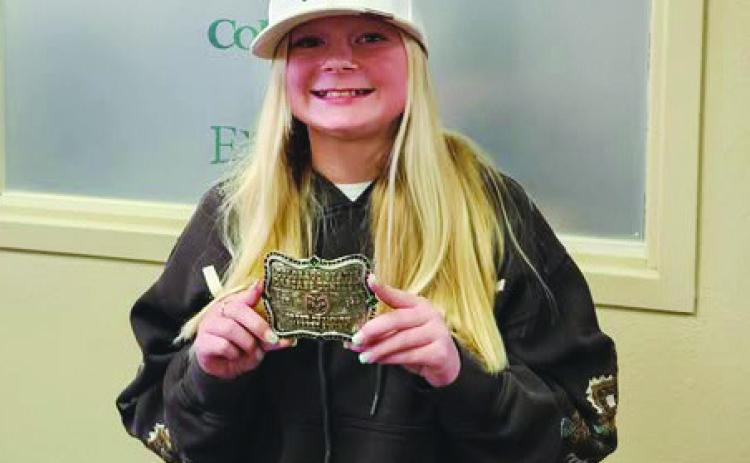 Stormy Kenney displays the belt buckle she won for the Statewide Colorado State Carcass Contest Grand Champion market swine winner for 2024. Courtesy Photo