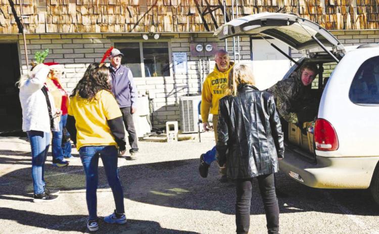 Colorado City Rye Lions and Leo Club members load a vehicle with food and toys to complete their annual Christmas drive. Courtesy Photo