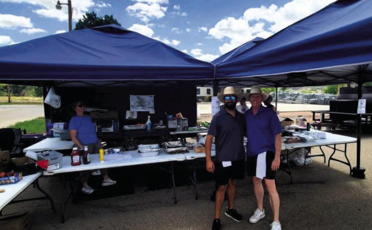 Tyson Rodriguez (L) and Chris Dorris of Insurance Busters.net step away from the grills for a moment to pose for a picture. Photo by Shirley Pigg