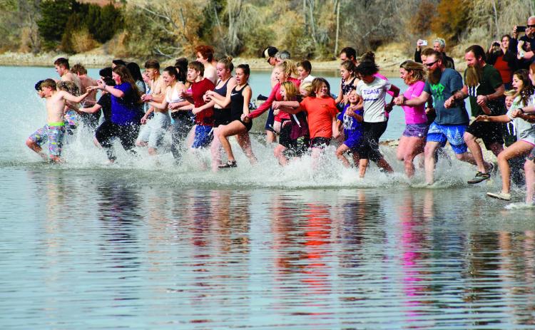 Participants in the 2021 Maggie Drew Peters Polar Plunge enter the water at Lake Beckwith in Colorado City to raise scholarship funds for Rye High School students.