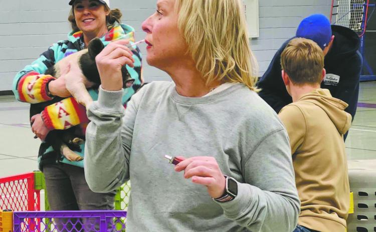 Best Photo - First Quarter 2025 - Shirley Pigg caught this photo as Craver Middle School teacher Erin Sonnleiter prepares to Kiss a Pig to benefit the Craver FFA Chapter Photo Archives