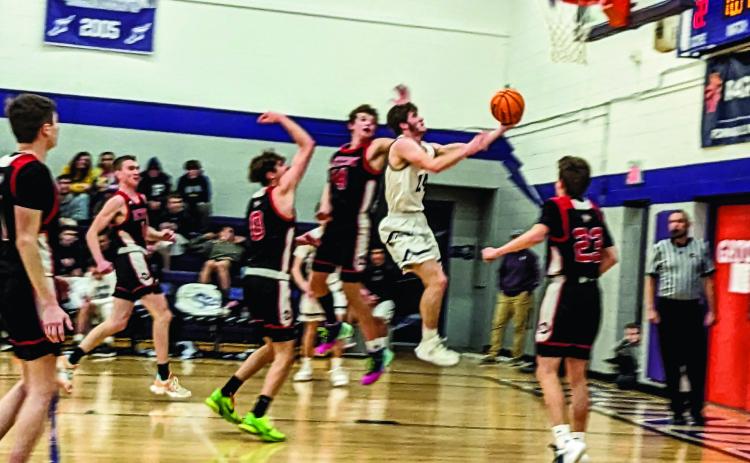 Rye High School Thunderbolt Brandon Benz (#24) makes an evasive move and basket against a Peyton player. Photo by Deb Straub