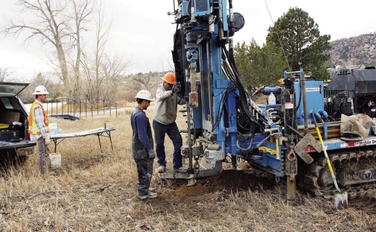 Lenny Jecminek (R), driller for RJU Consultants, prepares to take another sample of the soil near Lake Beckwith.